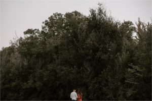 far away image of couple standing together, lots of space above them
